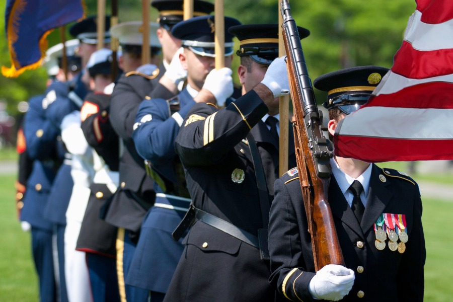 White-gloved honor guard members performing synchronized movements