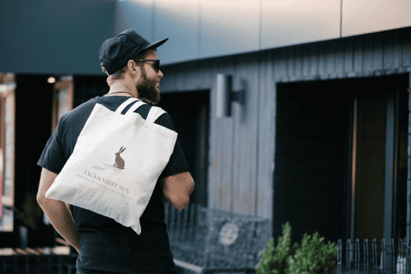 Person carrying a branded reusable tote bag in public
