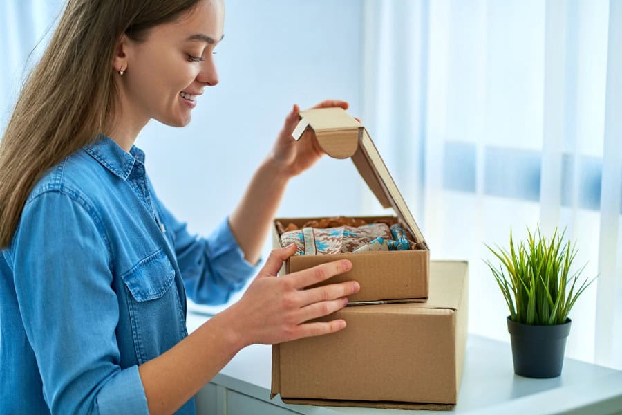 Customer opening an e-commerce box with decorative packaging inside