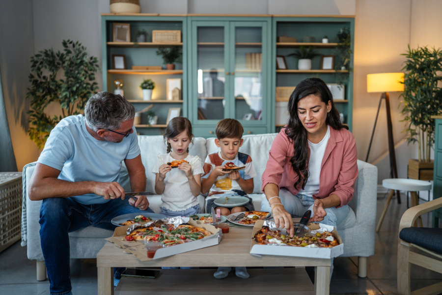 A happy family sharing a restaurant takeout meal together at home